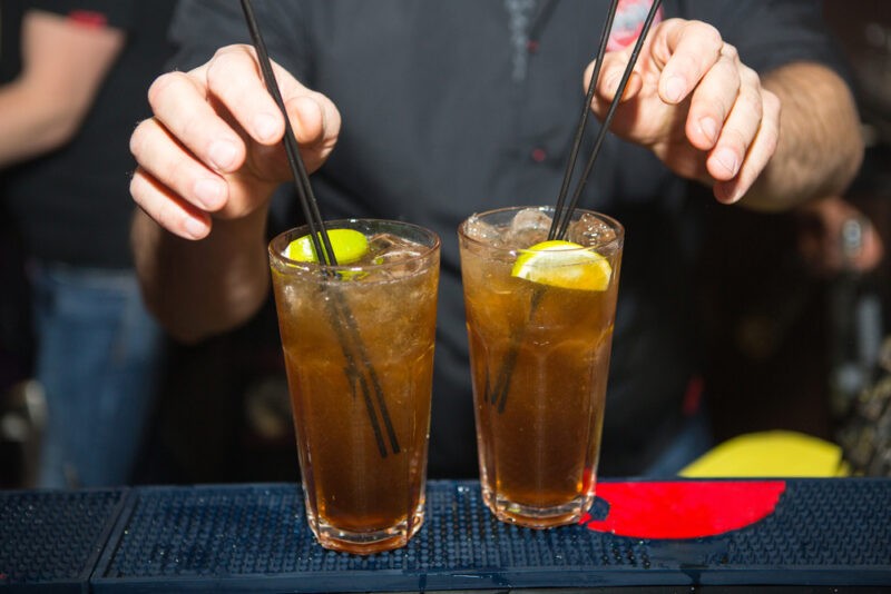 Long Island Iced Tea - barman pridáva slamky do pohárov