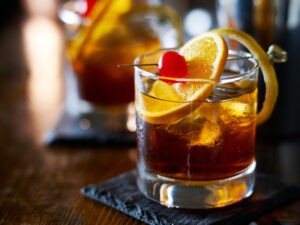 Drink Old fashioned v pohári s čerešničkou a pomarančom