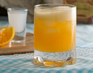 Ouzini oranžový drink v pohári