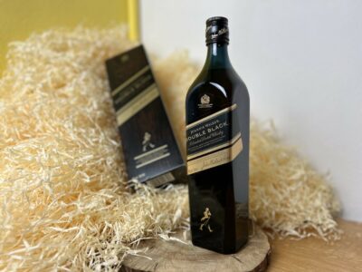 Johnnie Walker Double Black - celá fľaša na drevenom podnose a v pozadí kartón