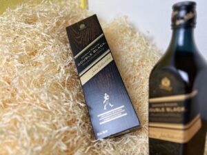 Johnnie Walker Double Black - fľaša na boku a detail na kartón