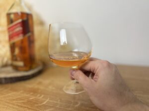 Johnnie Walker Red Label - pohár v ruke s alkoholom