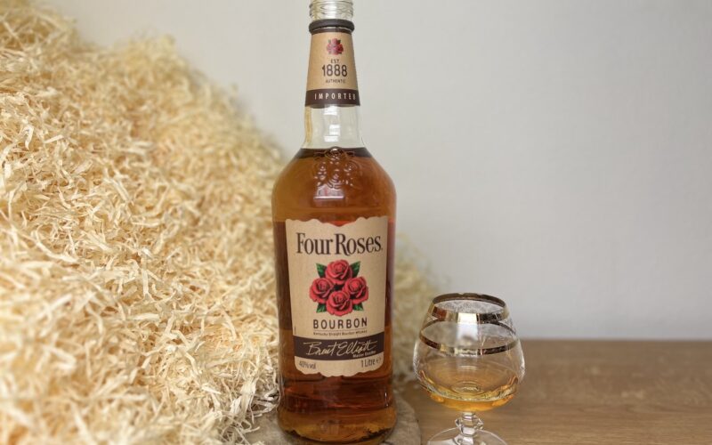 Four Roses Bourbon - degustácia, alkohol naliati v pohári a fľaša na drevenom podnose
