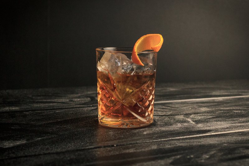 Bourbon Old Fashioned drink s ľadom a pásikom z pomarančovej kôry