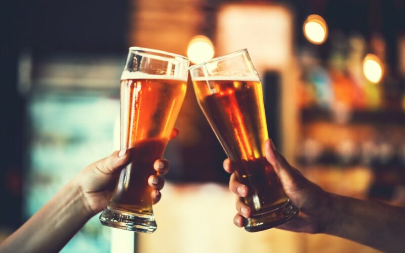 Dva poháre s pivom, muži si pripíjajú