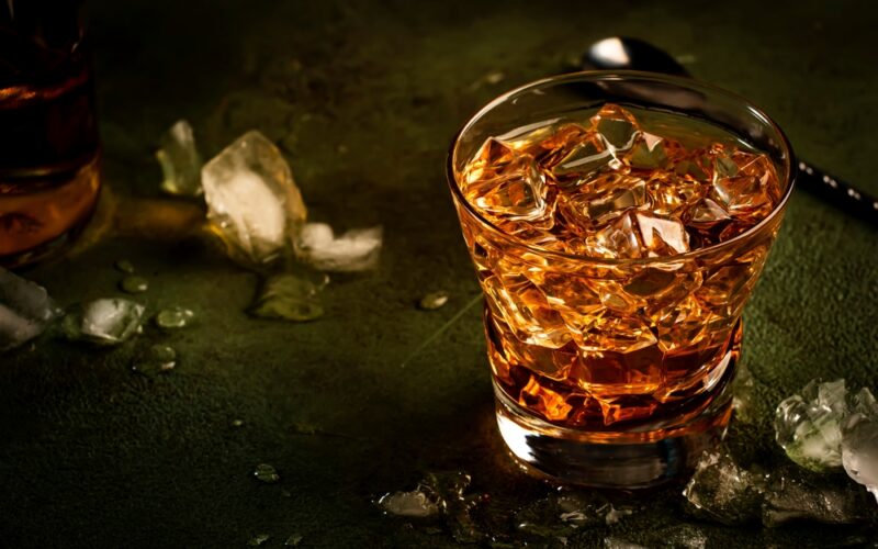 Godfather koktail so škótskou whisky, likérom amaretto a ľadom - na barovom pulte