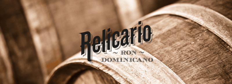 Relicario Ron Dominicano - logo značky na pozadí drevených sudov