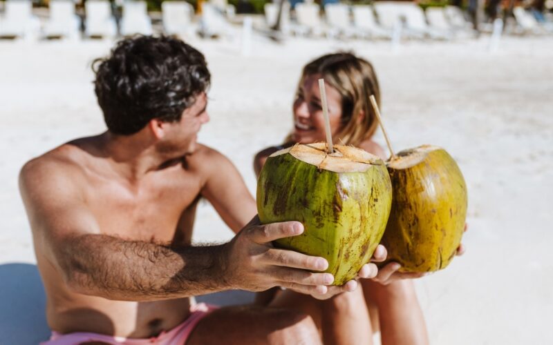 Kokosová voda, kokosové orechy so slamkou na pláži niekde v Latinskej Amerike